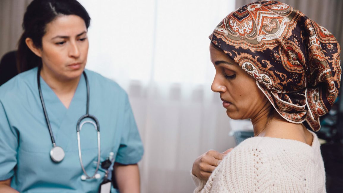 Un médecin parle avec une patiente qui porte un foulard sur la tête